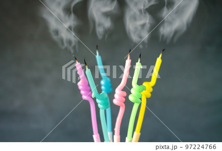 Birthday candles with flame blown out smoke on dark background 97224766