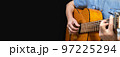 Guitarist playing acoustic guitar on black background, selective focus. 97225294