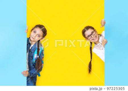 Girls sisters holding blue empy poster and smiling. Copyspace 97225305