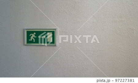 green emergency exit sign in case of evacuation from the building in case of fire, silhouette of a running person indicating the route to the doors to the right green emergency exit sign in case of evacuation from the building in case of fire, silhouette of a running person indicating the route to the doors to the right 97227381