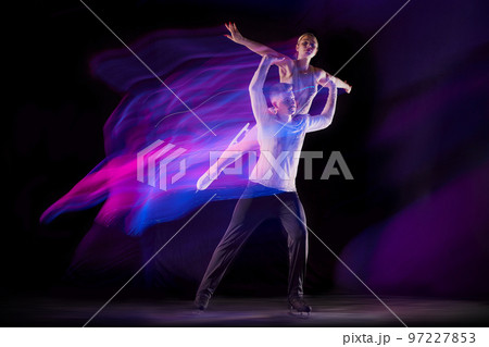 Support. Portrait of young man and woman, figure skating athletes dancing isolated over black background in neon with mixed lights Support. Portrait of young man and woman, figure skating athletes dancing isolated over black background in neon with mixed lights 97227853
