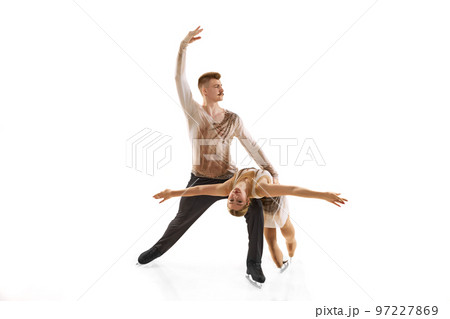 Portrait of young man and woman, figure skating athletes performing isolated over white studio background Portrait of young man and woman, figure skating athletes performing isolated over white studio background 97227869