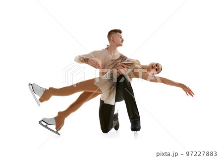 Portrait of young man and woman, figure skating athletes performing, dancing on stage costumes isolated over white studio background 97227883