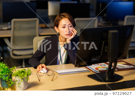 会社に残って遅くまで仕事をするビジネスウーマン 会社に残って遅くまで仕事をするビジネスウーマン 97229027