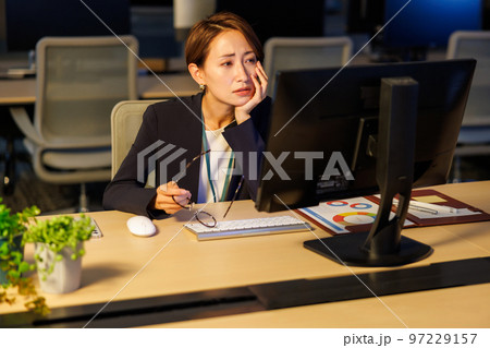 会社に残って遅くまで仕事をするビジネスウーマン 97229157