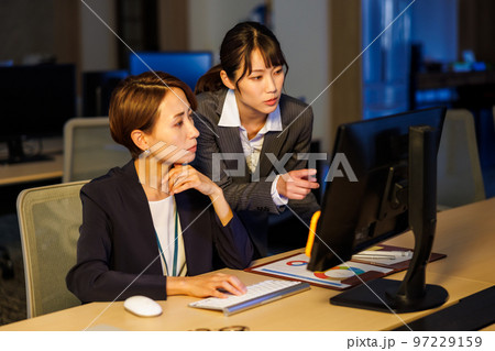 会社に残って遅くまで仕事をするビジネスウーマン 97229159