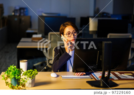 会社に残って遅くまで仕事をするビジネスウーマン 97229160