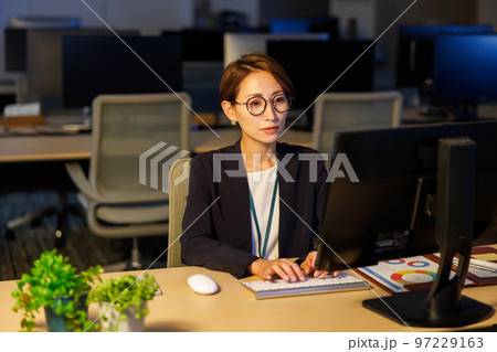 会社に残って遅くまで仕事をするビジネスウーマン 97229163