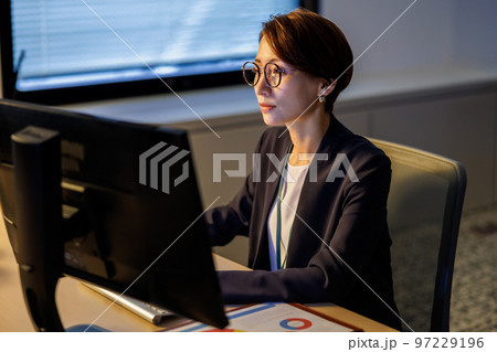 会社に残って遅くまで仕事をするビジネスウーマン 97229196