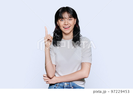 Happy young woman showing index finger up, over white background 97229453