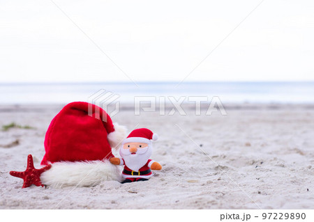 Santa Claus hat,starfish and Santa toy on the beach  97229890