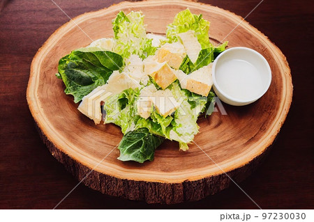 Bowl of green chicken caesar salad with fresh lettuce leaves 97230030