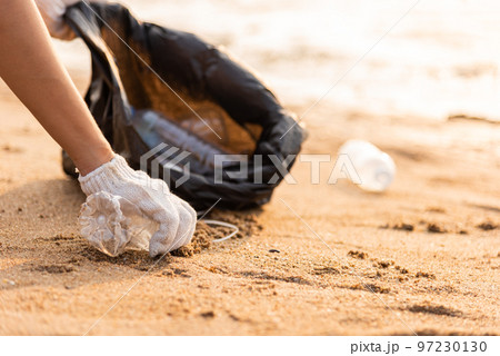 Volunteer woman picking plastic bottle into trash plastic bag black for cleaning the beach, female clean up garbage, Ecology concept and World Environment Day, Save earth concept Volunteer woman picking plastic bottle into trash plastic bag black for cleaning the beach, female clean up garbage, Ecology concept and World Environment Day, Save earth concept 97230130