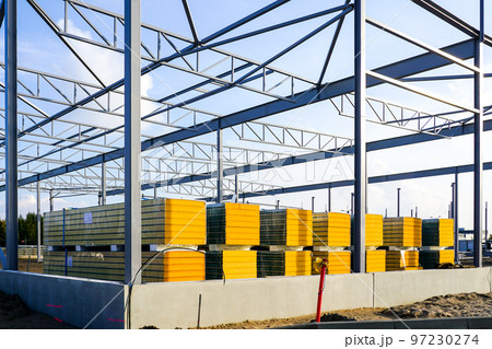 Assembled steel framework and stacks of sandwich panels for the facade of a new industrial building Assembled steel framework and stacks of sandwich panels for the facade of a new industrial building 97230274