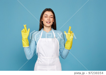girl in yellow rubber gloves with finger crossed gesture 97230354