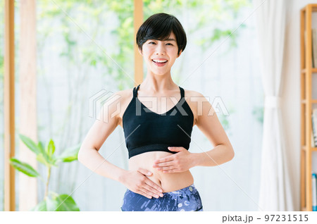 お腹の調子を確認する若い女性 97231515