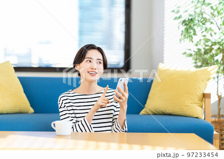 リビングでスマートフォンを操作する女性 97233454
