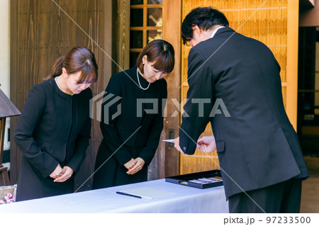 お葬式で芳名録・芳名帳にサインする高齢者の日本人男性 お葬式で芳名録・芳名帳にサインする高齢者の日本人男性 97233500