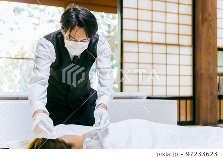 故人に打ち覆い・面布をかける納棺師・セレモニースタッフ・葬祭ディレクターの日本人男性（マスク） 97233623