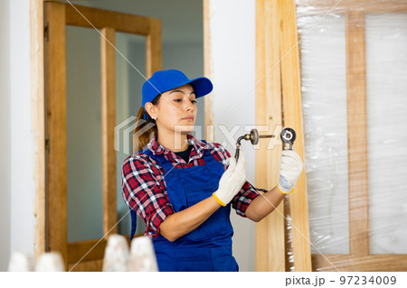 Woman builder assembling door handle 97234009