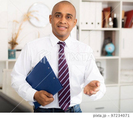 Manager in office standing near workplace Manager in office standing near workplace 97234071