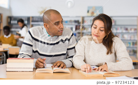 Latin american man and woman studying in university library 97234123