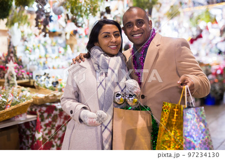 Portrait of happy elegant couple with gift bags at new year fair 97234130