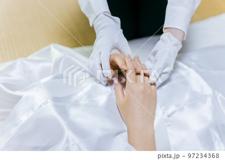 故人の手を組む湯灌師・納棺師・おくりびと・エンバーマーの日本人女性(エンゼルケア・清拭) 故人の手を組む湯灌師・納棺師・おくりびと・エンバーマーの日本人女性(エンゼルケア・清拭) 97234368