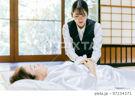 故人の体を拭く湯灌師・納棺師・おくりびと・エンバーマーの日本人女性（エンゼルケア・清拭） 97234371