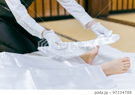 故人の死装束・脚絆をつける湯灌師・納棺師・おくりびと・エンバーマーの日本人女性(エンゼルケア・清拭) 故人の死装束・脚絆をつける湯灌師・納棺師・おくりびと・エンバーマーの日本人女性(エンゼルケア・清拭) 97234789