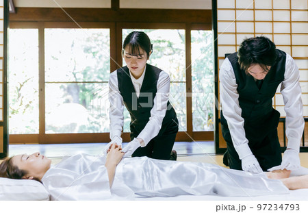 故人の手を組む湯灌師・納棺師・おくりびと・エンバーマーの日本人女性（エンゼルケア・清拭） 97234793