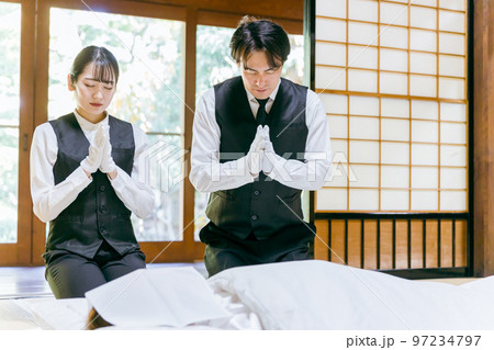 故人に手を合わせる湯灌師・納棺師・おくりびと・エンバーマー・セレモニースタッフの日本人男女 故人に手を合わせる湯灌師・納棺師・おくりびと・エンバーマー・セレモニースタッフの日本人男女 97234797