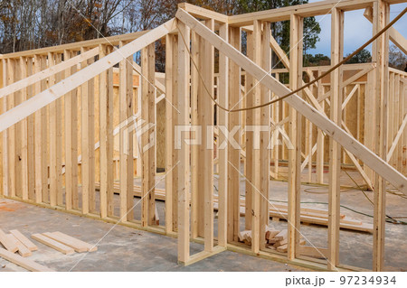 Wood framing beam is being installed to support the roof of newly constructed house 97234934