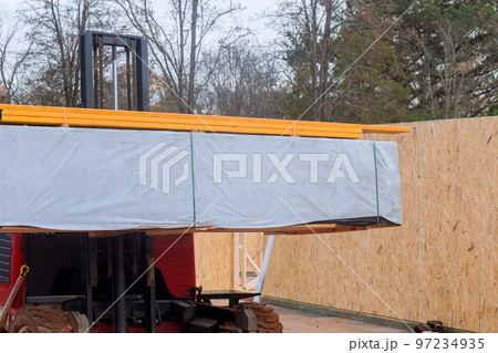 Construction building materials are being unloaded with help of forklift in construction site 97234935