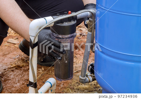 Replace replaceable filters for cleaning water near home by professional workers performing maintenance work replacing replaceable filters in outside parts of house 97234936