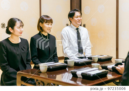親族・遺族で集まった法事・お彼岸・お葬式の食事シーン（笑顔） 97235006