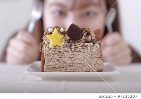 ケーキが食べたいけど、我慢している女性 97235307