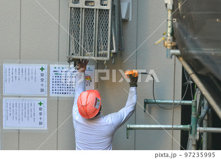 マンション大規模修繕　仮設足場の荷揚リフトの作業風景 97235995
