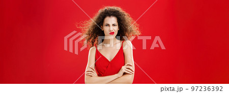 Woman in rage and fury seeing husband flirting with waitress during date in restaurant holding hands crossed on chest frowning and smirking from anger and irritation while hair flicks on air Woman in rage and fury seeing husband flirting with waitress during date in restaurant holding hands crossed on chest frowning and smirking from anger and irritation while hair flicks on air 97236392