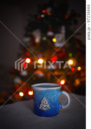 blue cup with hot on the background of a christmas tree with lights in the bokeh 97236666