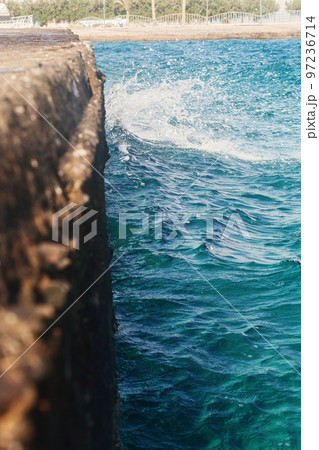 the waves strike the stone pier in blurring 97236714