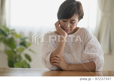 悩むミセス女性、頭痛・考えこむ日本人女性イメージ 97237347