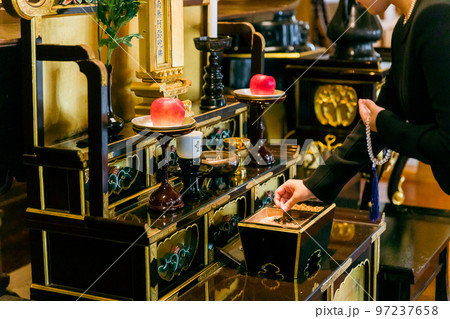 お葬式で焼香台に立つ喪服の女性の手元（お焼香） 97237658