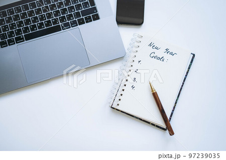 open notepad with text new year resolutions. and empty list. Laptop and smartphone on background open notepad with text new year resolutions. and empty list. Laptop and smartphone on background 97239035