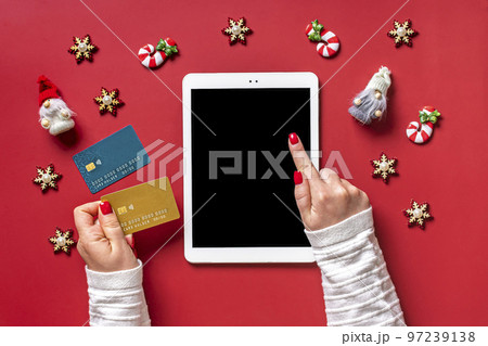top view female hands holding credit card, tablet with black digital screen, Christmas decor on red table Flat lay Holiday shopping list, Happy New Year, online shop, chooses gifts, makes purchases. top view female hands holding credit card, tablet with black digital screen, Christmas decor on red table Flat lay Holiday shopping list, Happy New Year, online shop, chooses gifts, makes purchases. 97239138