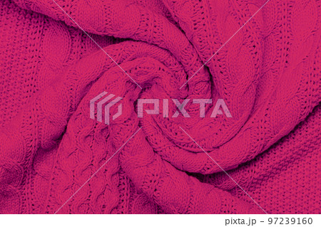 The texture of warm knitted sweater. Beautiful handmade knitted repeating pattern. Demonstrating Pantone color of the year 2023 viva magenta. The texture of warm knitted sweater. Beautiful handmade knitted repeating pattern. Demonstrating Pantone color of the year 2023 viva magenta. 97239160