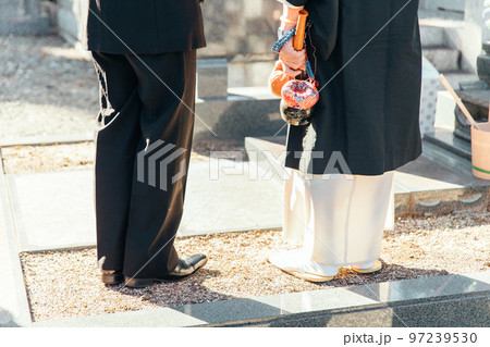 お墓・墓地・霊園で納骨式をする日本人の遺族と住職 97239530