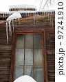 Icy, small icicles hang on the edge of the roof, winter or spring. 97241910
