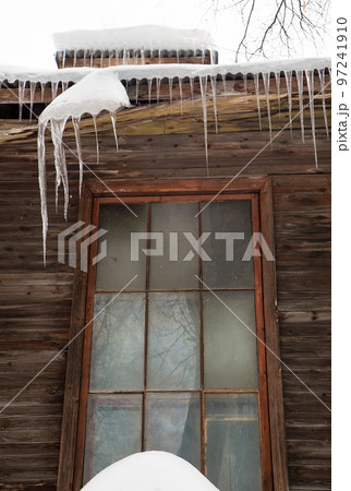 Icy, small icicles hang on the edge of the roof, winter or spring. Icy, small icicles hang on the edge of the roof, winter or spring. 97241910