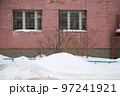 A small snowdrift on the background of the brick wall of the building. 97241921